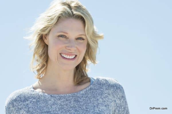 Portrait of mature woman smiling against clear sky