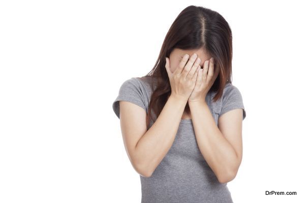 Sad young Asian woman crying with face on palm  isolated on white background