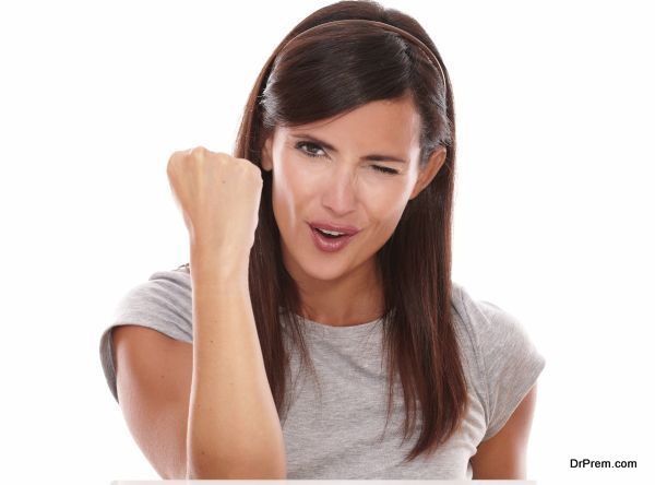 Front view portrait of adult woman with winking eye and winning gesture looking at camera on isolated studio