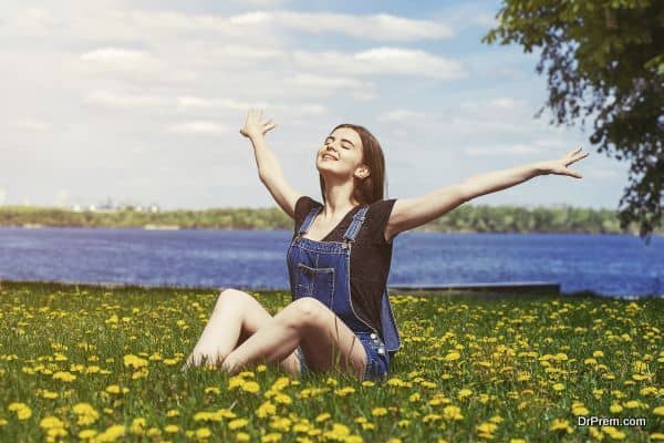 happy girl sitting on green grass