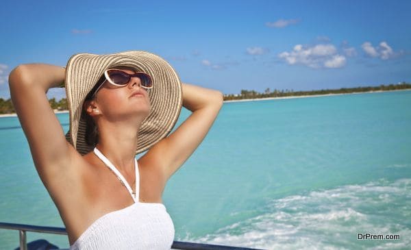 Young beautiful women dreaming on the deck of a yacht at Caribbean sea. Woman resting on the water. Summer cruise holidays