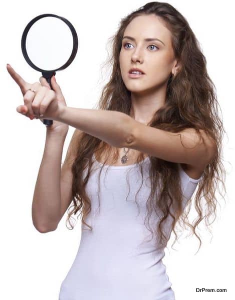 Surprised woman looking through magnifying glass