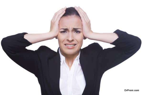 Stressed businesswoman. Frustrated young woman in formalwear holding head in hands and looking at camera while standing isolated on white