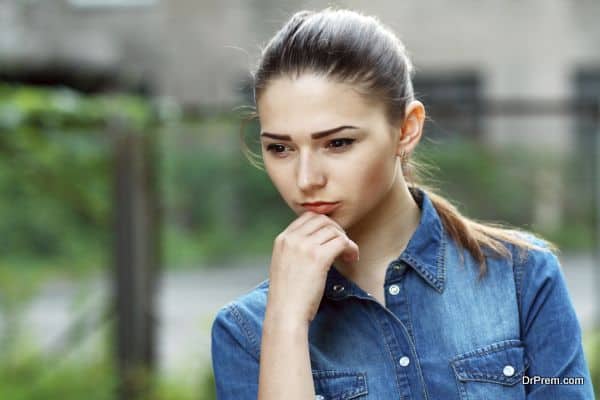 Outdoor portrait of a sad teenage girl looking thoughtful about troubles