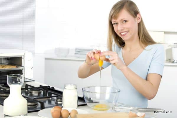 Beautiful woman in kitchen is making a cake