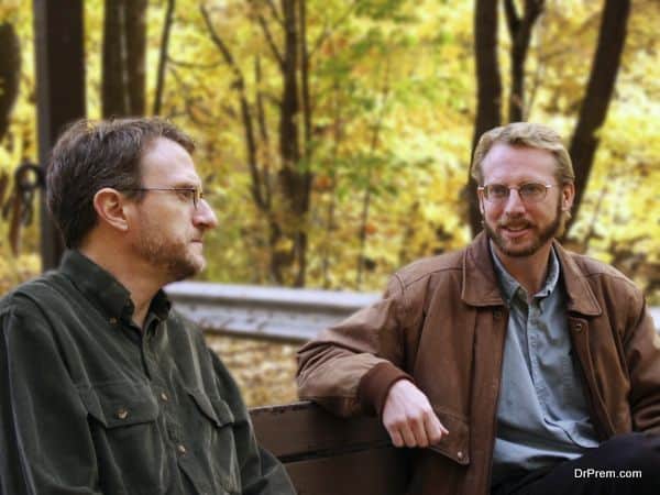 men, coworkers, colleagues, males, friends, pals, buddies, chums, bench park, seated lunch, discussion, serious, smile, trees, autumn, foliage, leaves, yellow, jacket, beard, mustache, glasses, talk, listen, chat, adults, two, nature