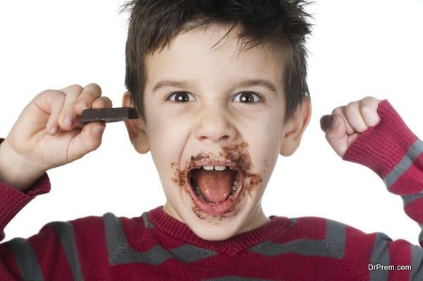 Smiling little boy eating chocolate