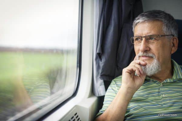 Senior man enjoying a train travel - leaving his car at home, he