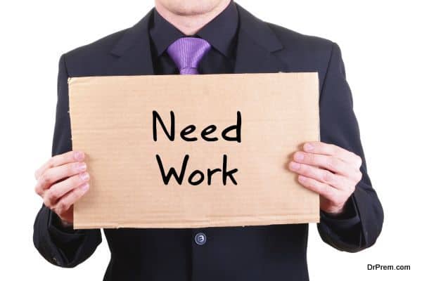 unemployed businessman with cardboard sign "Need Work"