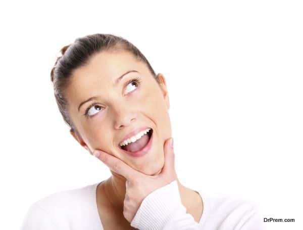 A portrait of a young beautiful woman lost in her thoughts over white background