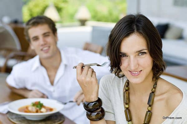 A young couple on vacation eating lunch at a relaxed outdoor restaurant