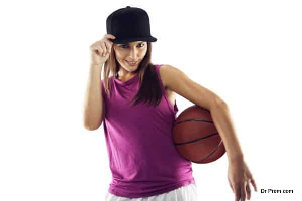 Beautiful and sporty woman holding basketball