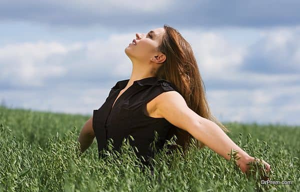 Happy young woman relaxing in a field.