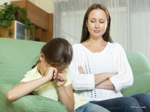 beautiful woman scolding crying child at home interior. Focus on girl