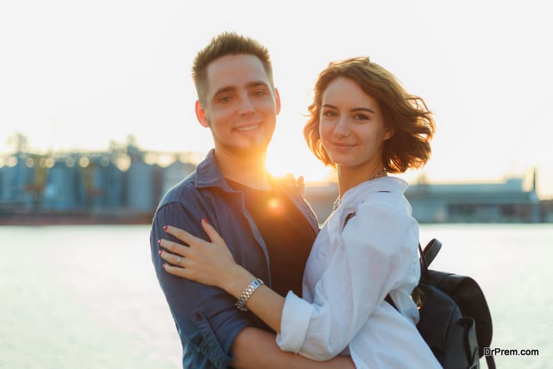 Portrait of a young smiling couple of lovers at sunset on the sea