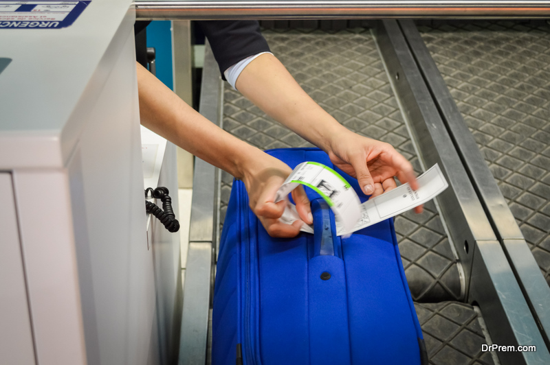 Check-in employee attaches a luggage tag