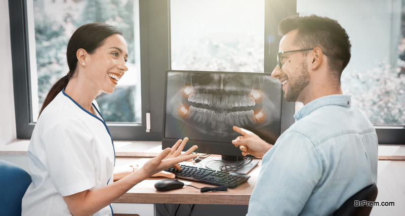 Dentist and patient choosing treatment in a consultation with x-ray image on screen