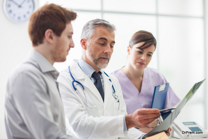 Doctor examining an x-ray and pointing, the patient is listening and watching