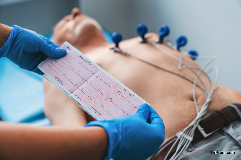 Electrocardiogram, ECG in hand. Cardiogram printout on male patient