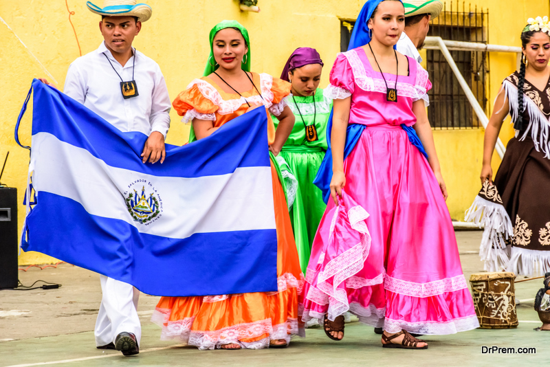 Folk dancers with El Salvador national flag