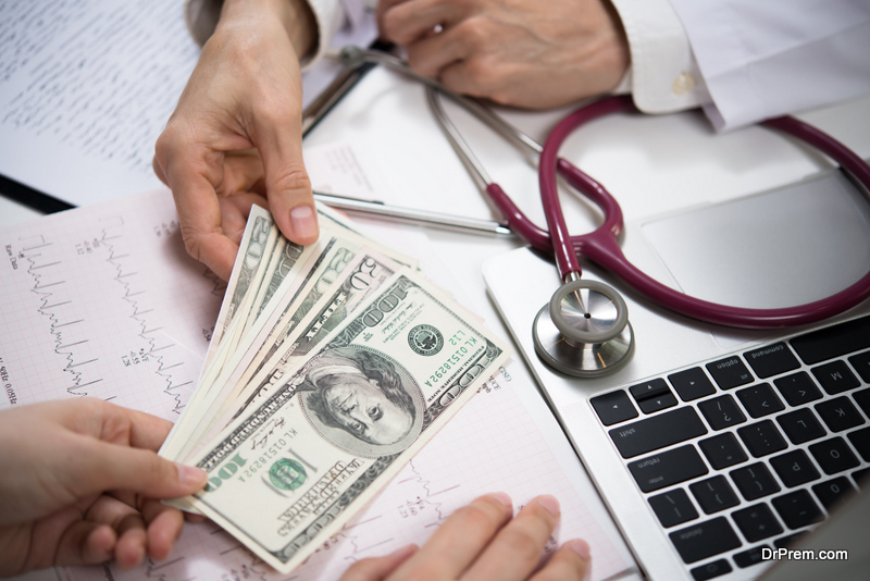 Patient giving money to medical doctor in hospital 