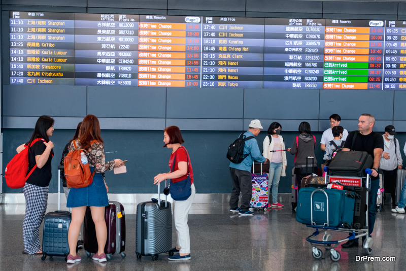 People are waiting around the timetable area in Taoyuan International Airport, Taipei, Taiwan