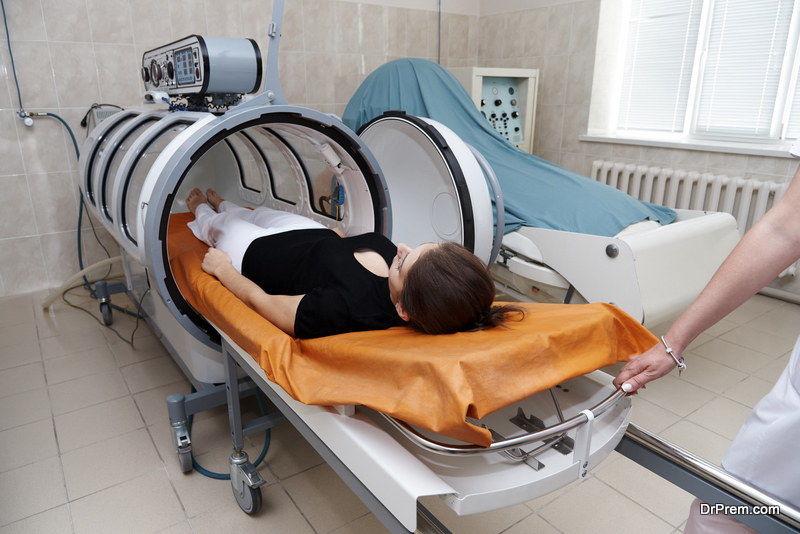 The girl is undergoing a medical procedure in a hyperbaric chamber