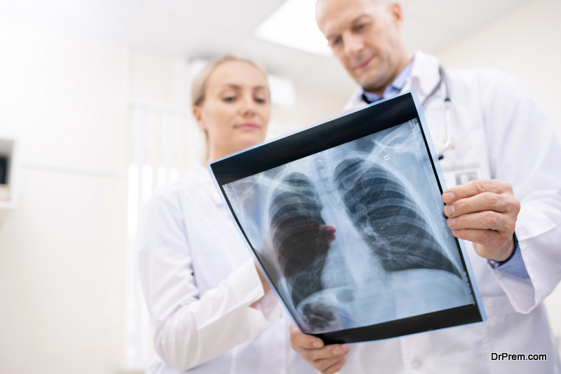 X-ray of lungs or spinal cors held by one of doctors in whitecoats during consultation and discussion of its details