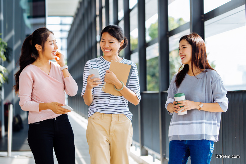 Young Asian women talking while walking in office building