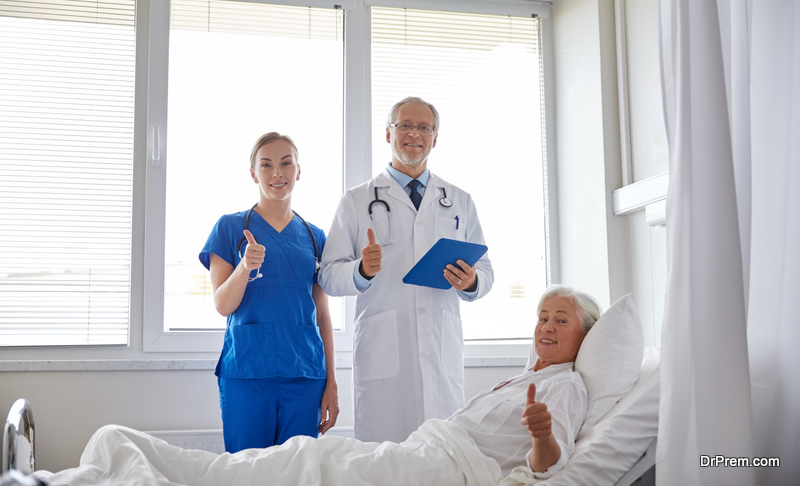 doctor and nurse with tablet pc computer visiting senior patient woman and showing thumbs up at hospital ward