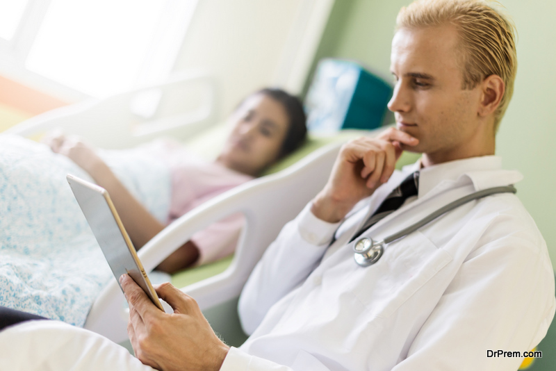 doctor consulting patient lying on hospital bed 