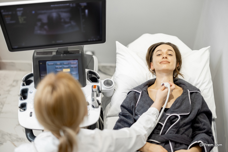 Doctor examining thyroid of female patient