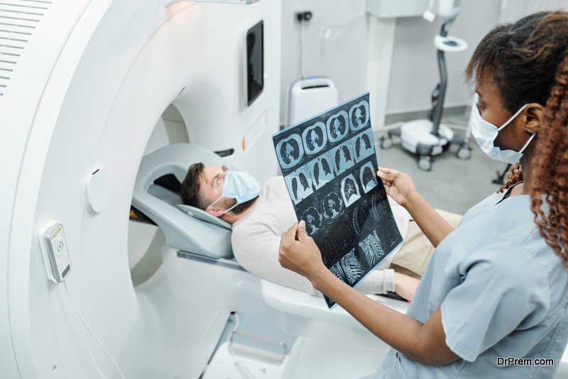 radiologist in uniform and protective mask looking at x-ray 