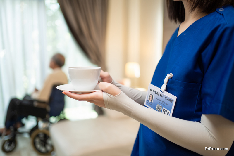 Asian beautiful doctor serve coffee to old patient 