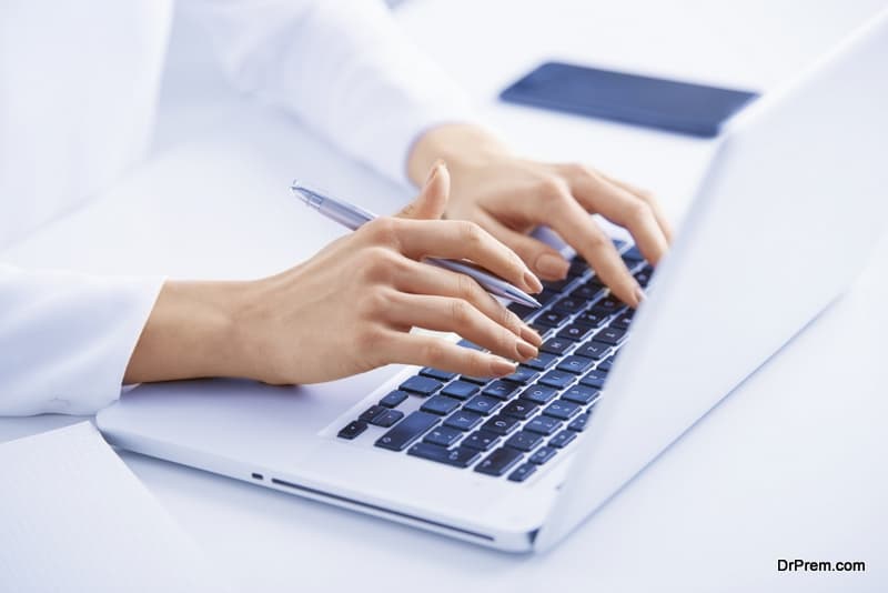 Close-up up shot of young businesswoman's hand typing on notebook's keyboard.
