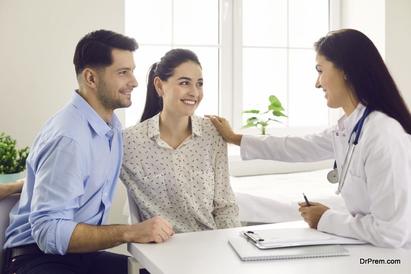 Female doctor consulting young couple patients