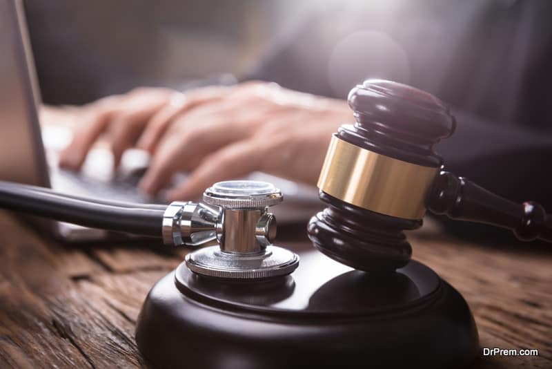 Close-up Of Stethoscope And Gavel On Wooden Desk