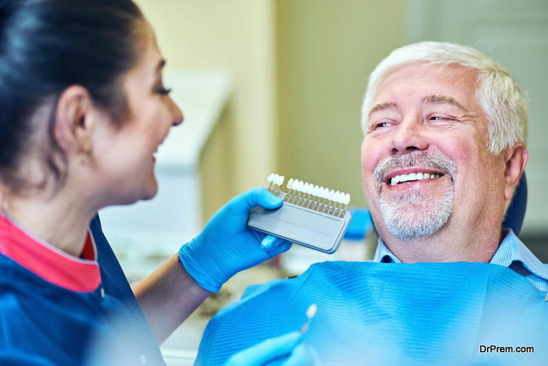 Dentist comparing patient's teeth shade with samples for bleaching treatment