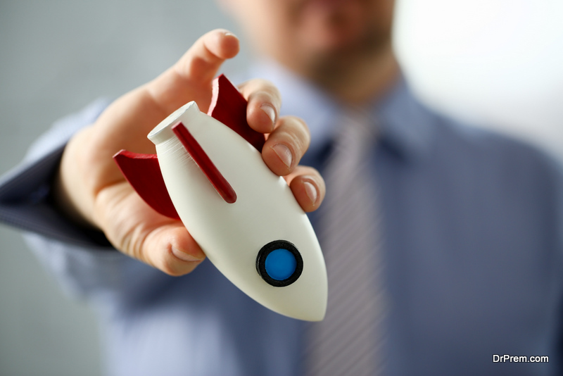 Businessman in suit hold white rocket in hand down 