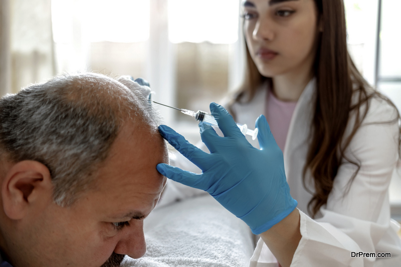 female beautician doctor makes injections in the man head for hair growth against hair loss and baldness