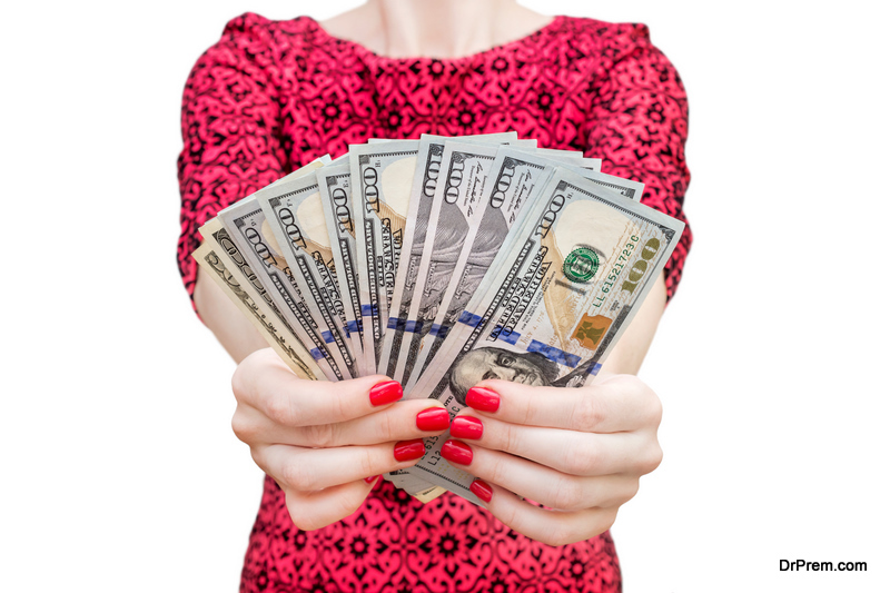 Woman in red dress holding bunch of dollar bills