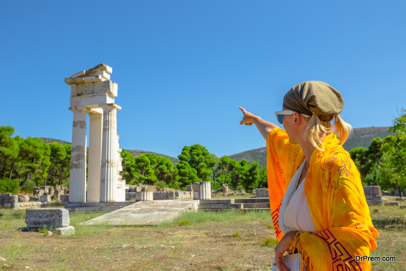 Greek dressed woman in indicates the ruins of Temple of Asklepieion, Epidaurus, Peloponnese, Greece