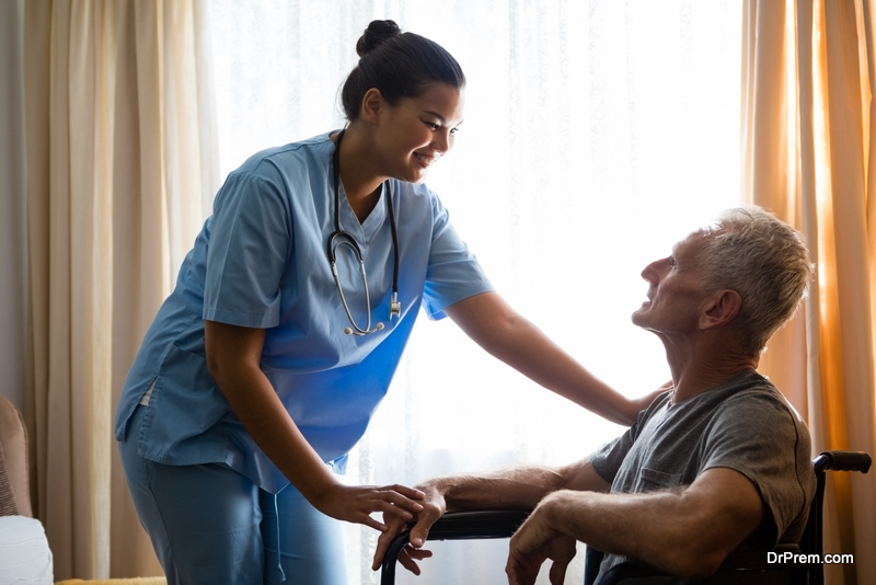 Smiling female doctor interacting with senior man in nursing home