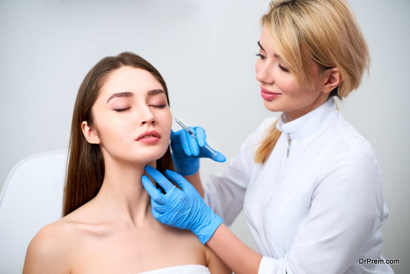 Beautician doctor with botulinum toxin syringe making injection to to remove crow's feet