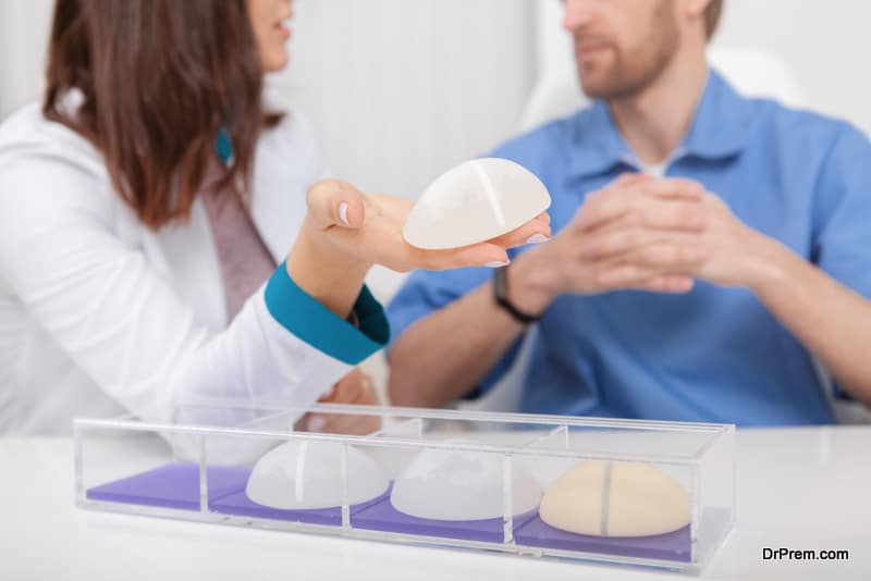 Cropped shot of a female plastic surgeon talking to her male colleague, holding silicone breast implant