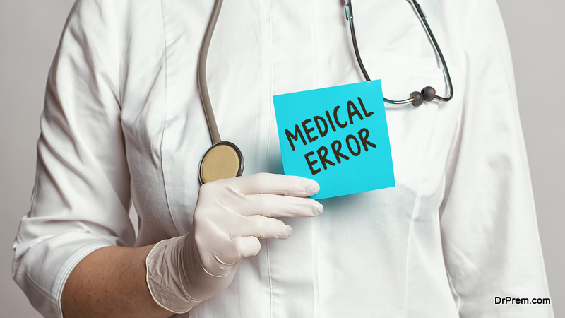 Cropped view of doctor in a white coat and sterile gloves holding a note with text - medical error. Medical concept