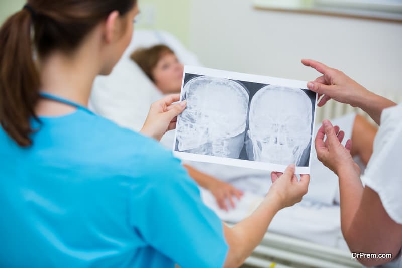 Nurses checking a x-ray of patient in ward at hospital