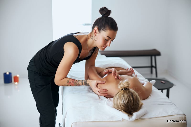 Side view portrait of dark hair female doing aroma massage for blonde elegant lady in beauty clinic