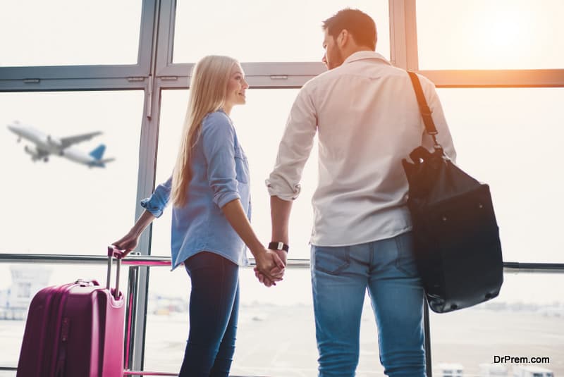 couple in airport. Attractive young woman and handsome man with suitcases are ready for traveling