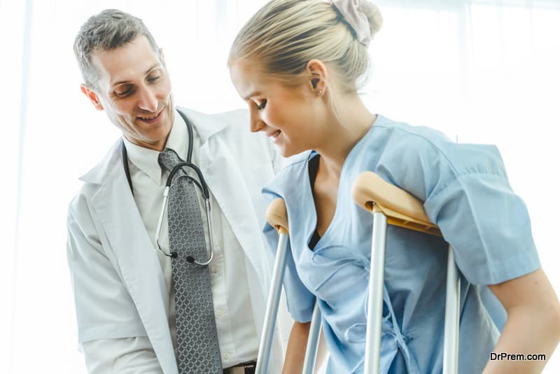 Doctor takes care of patient in crutch at hospital or clinic